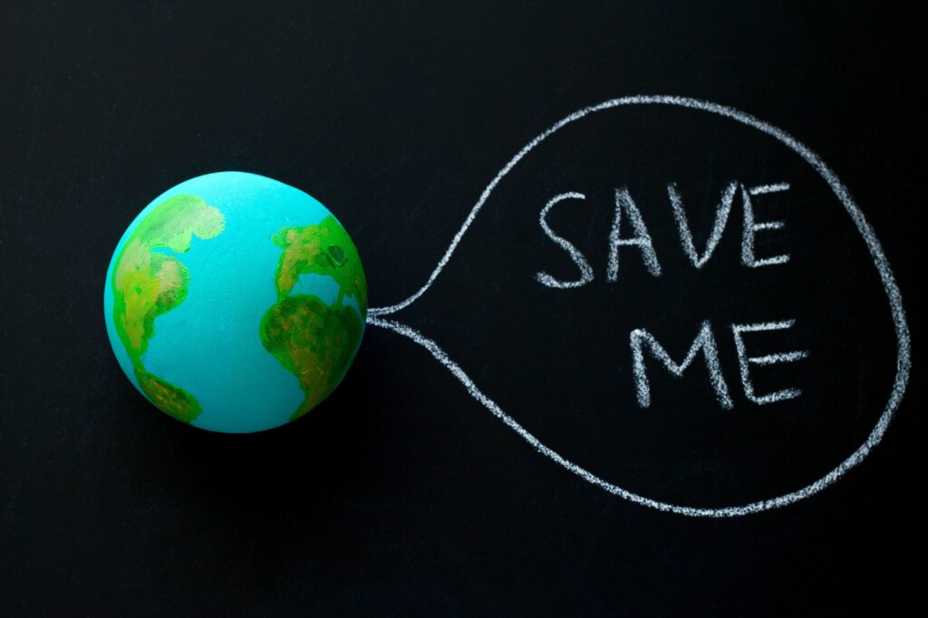 homemade model of the Earth planet on a chalkboard with the inscription save me